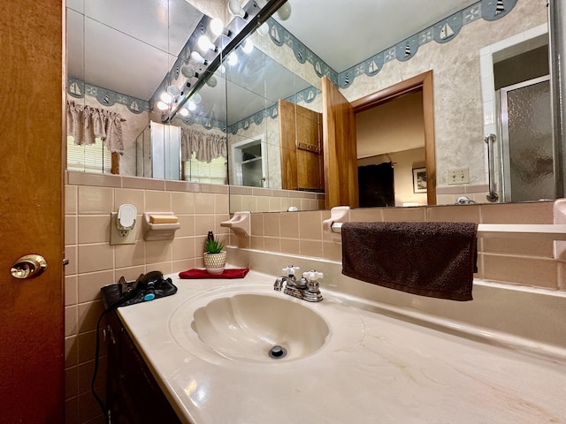 bathroom featuring vanity, tasteful backsplash, and tile walls