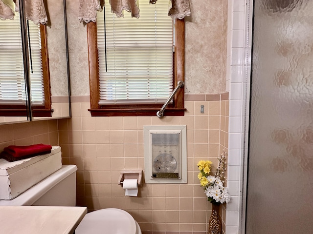 bathroom featuring an enclosed shower, tile walls, a wainscoted wall, and toilet
