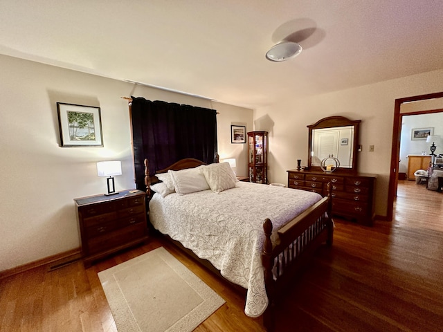 bedroom with baseboards and dark wood finished floors