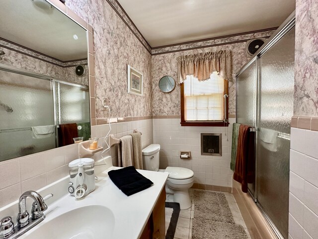 full bathroom featuring vanity, tile walls, tile patterned flooring, and a shower stall