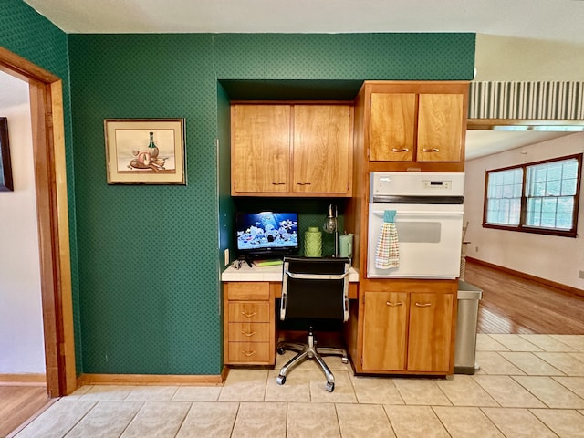 office space featuring built in study area, baseboards, and light tile patterned flooring