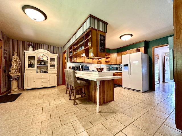 kitchen featuring open shelves, light countertops, a kitchen breakfast bar, white fridge with ice dispenser, and a peninsula