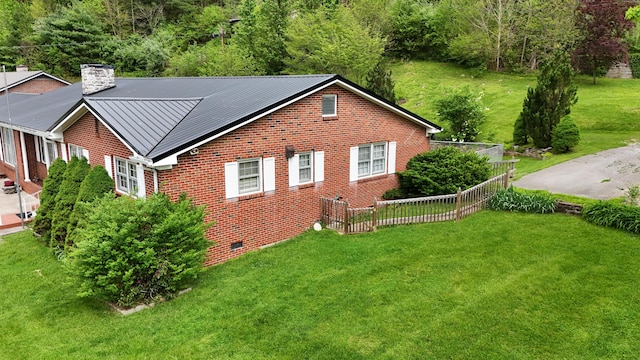 rear view of house with a lawn, a chimney, brick siding, and crawl space