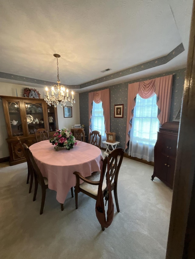 dining area with light carpet, visible vents, a chandelier, and wallpapered walls
