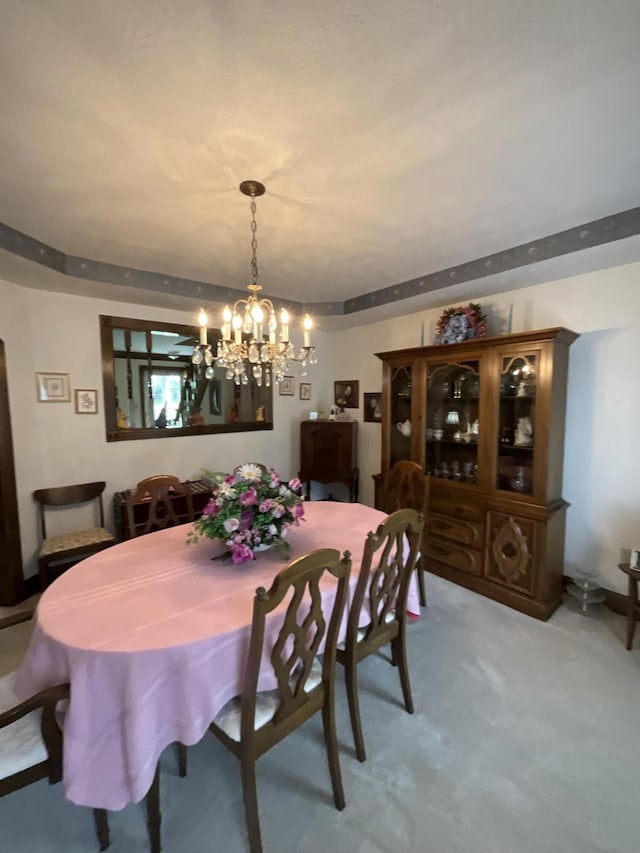 dining room with light carpet and a notable chandelier