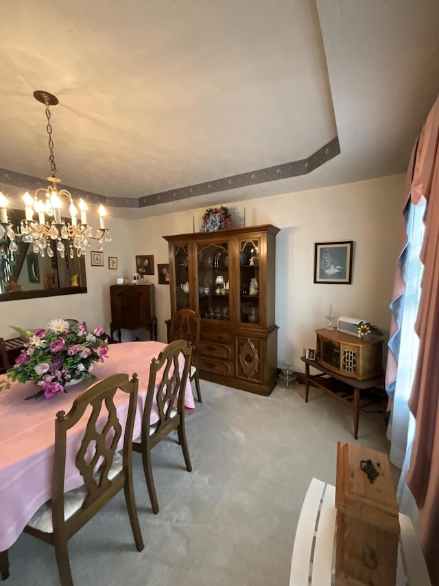 dining space with a notable chandelier and light colored carpet