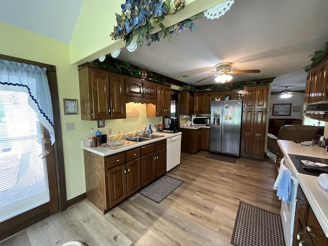 kitchen with light wood-style flooring, a sink, a ceiling fan, white appliances, and light countertops