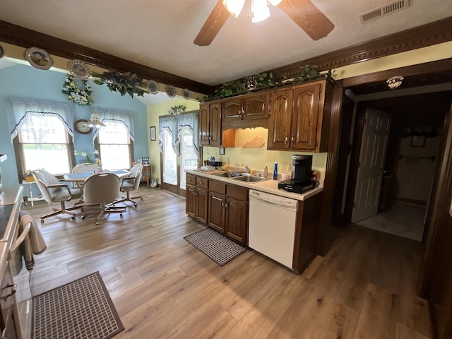 kitchen featuring light wood finished floors, dishwasher, visible vents, a ceiling fan, and a sink