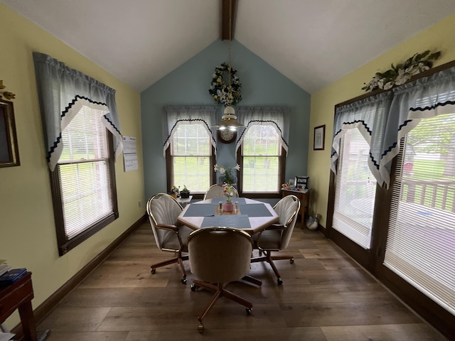 dining space featuring a wealth of natural light, wood finished floors, and vaulted ceiling with beams
