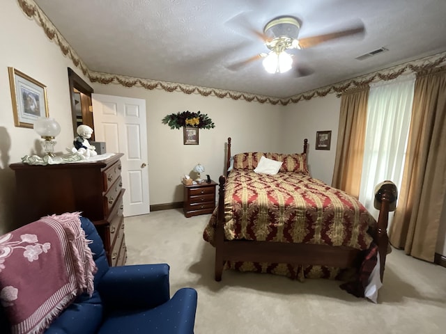 bedroom featuring visible vents, a ceiling fan, and light carpet