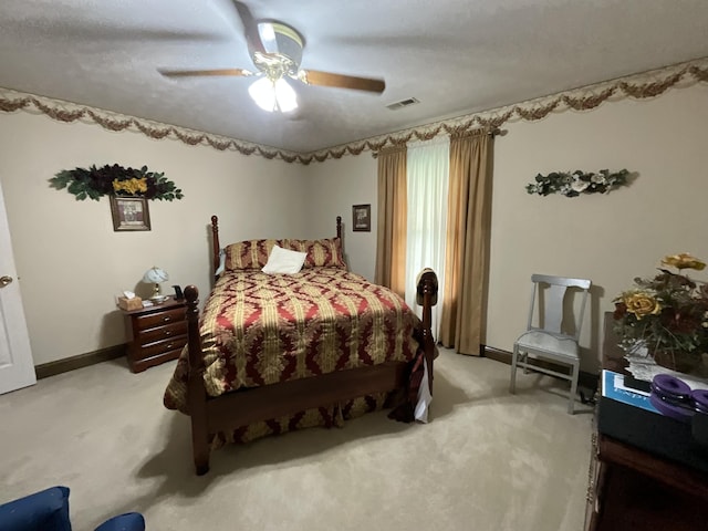 bedroom with light colored carpet, ceiling fan, baseboards, and visible vents