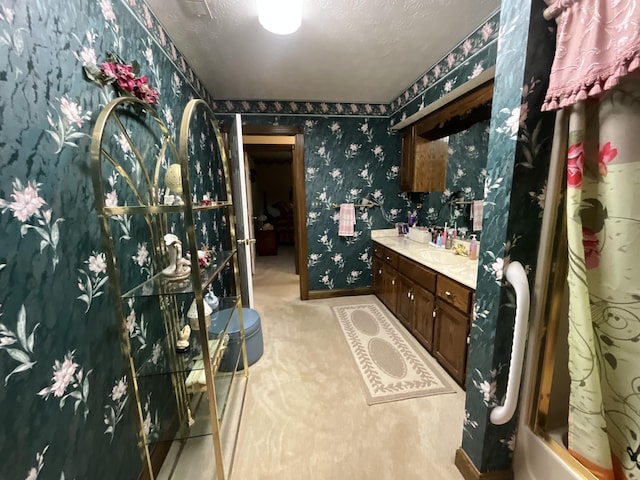 bathroom featuring wallpapered walls, vanity, and a shower