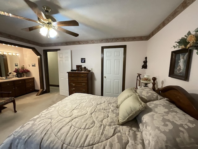 bedroom with arched walkways, baseboards, light colored carpet, and ceiling fan