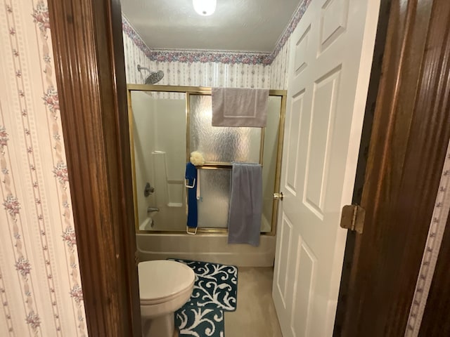bathroom featuring enclosed tub / shower combo and toilet