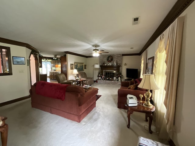 carpeted living area featuring visible vents, a ceiling fan, a brick fireplace, and crown molding
