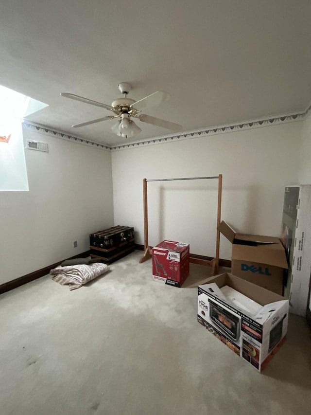 interior space featuring ceiling fan, baseboards, visible vents, and carpet