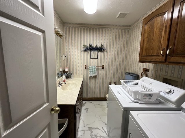 laundry room featuring marble finish floor, visible vents, a sink, separate washer and dryer, and cabinet space