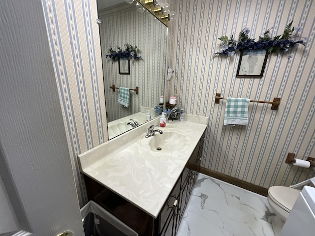 bathroom featuring marble finish floor, toilet, vanity, and baseboards