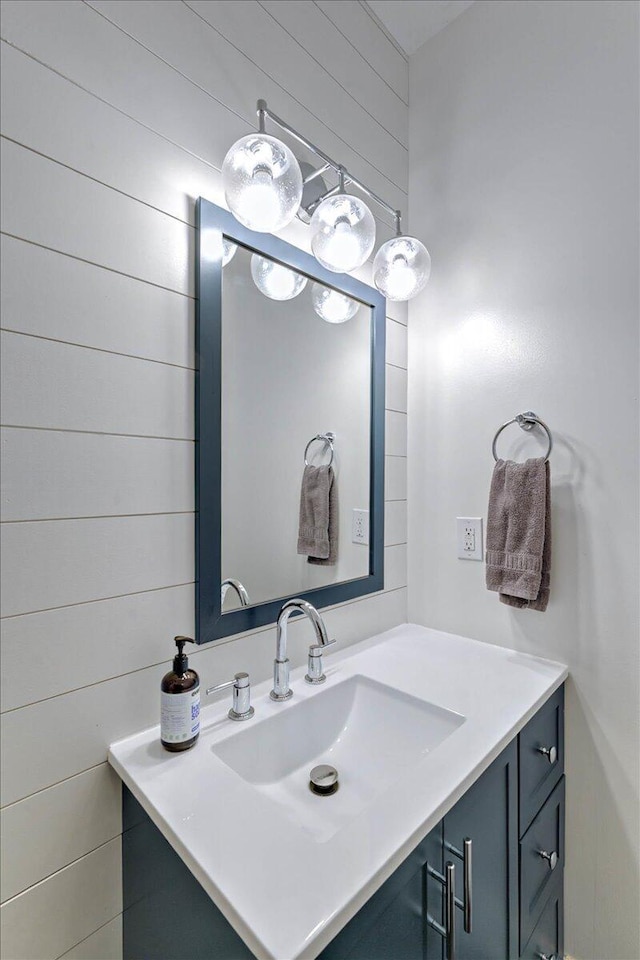 bathroom featuring wooden walls and vanity