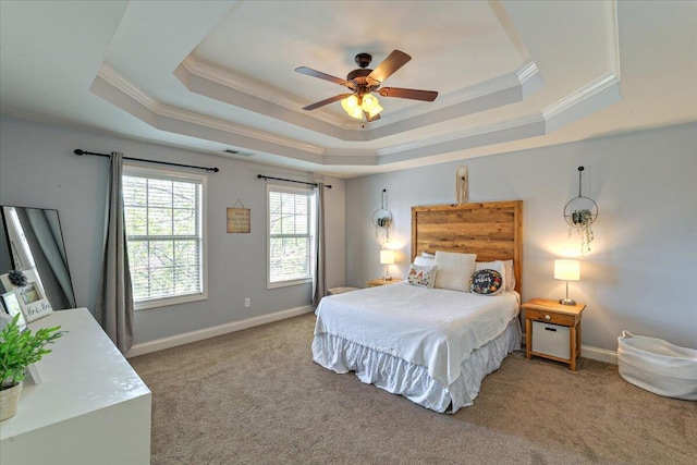 bedroom featuring carpet floors, baseboards, crown molding, and a tray ceiling