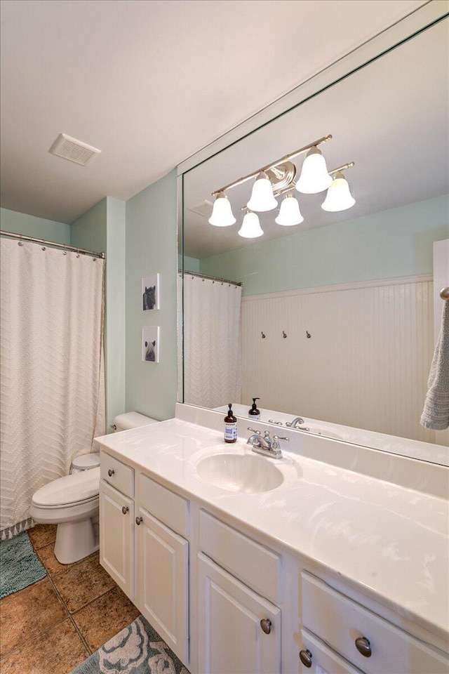 bathroom with toilet, visible vents, tile patterned flooring, and vanity