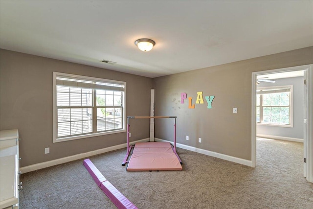 unfurnished bedroom with visible vents, carpet, and multiple windows
