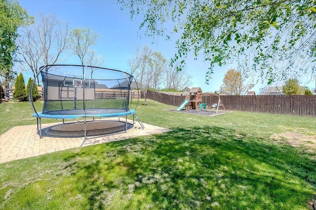 view of yard featuring a playground, a fenced backyard, and a trampoline