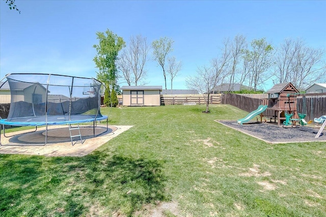 view of yard featuring a playground, a storage unit, a trampoline, and a fenced backyard