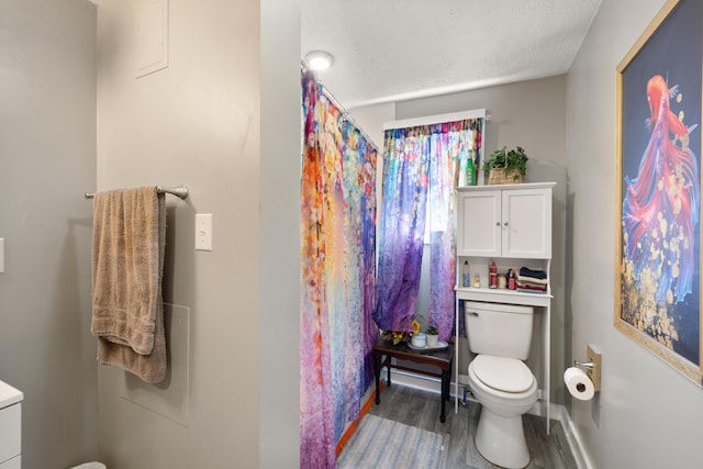 3576 Elkhorn Rd, Campbellsville, KY 42718 - bathroom with toilet, a textured ceiling, baseboards, wood finished floors, and a shower with curtain