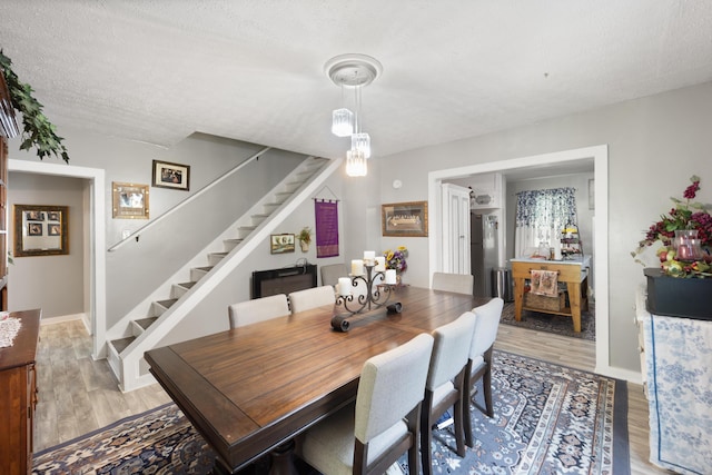 3576 Elkhorn Rd, Campbellsville, KY 42718 - dining area with light wood-style floors, a textured ceiling, baseboards, and stairway