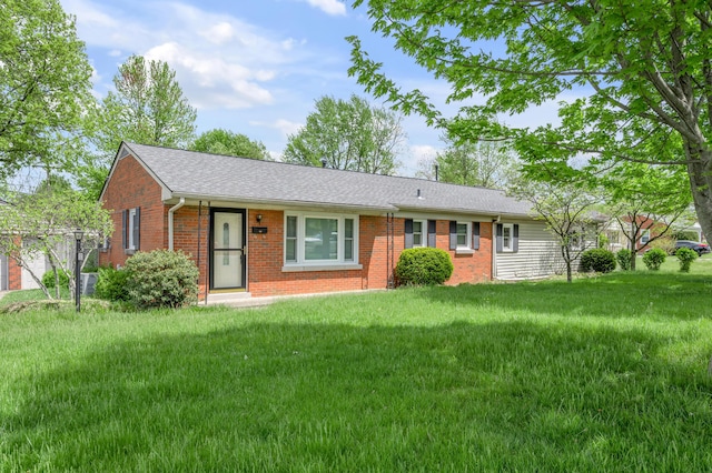 single story home with roof with shingles, a front lawn, and brick siding
