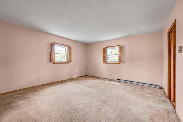 spare room with plenty of natural light, carpet floors, and a baseboard radiator