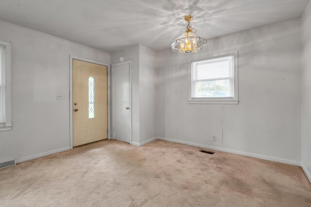 entryway with an inviting chandelier, visible vents, and baseboards
