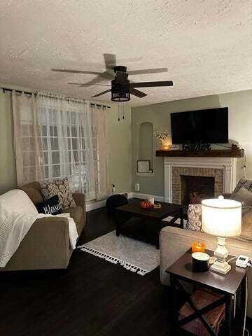 121 Hill Ct, Lancaster, KY 40444 - living area with a textured ceiling, wood finished floors, a ceiling fan, and a brick fireplace