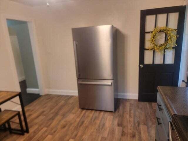 121 Hill Ct, Lancaster, KY 40444 - kitchen featuring freestanding refrigerator, baseboards, dark countertops, and wood finished floors