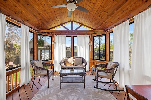 sunroom / solarium featuring a wealth of natural light, wood-type flooring, a ceiling fan, and lofted ceiling