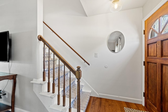 foyer entrance with baseboards, stairs, and wood finished floors