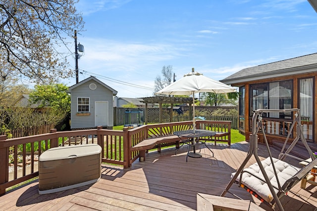 wooden terrace featuring a fenced backyard, outdoor dining space, an outbuilding, and a shed