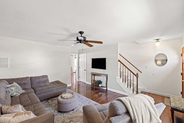 living area with baseboards, stairs, ceiling fan, and wood finished floors