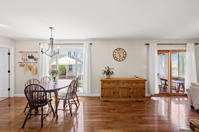 dining area with baseboards, a chandelier, a wealth of natural light, and hardwood / wood-style floors