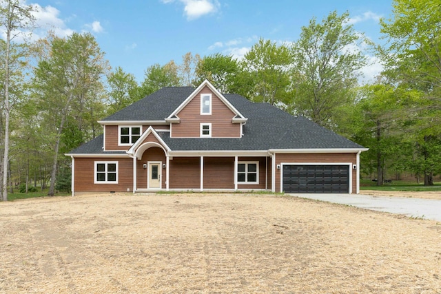 craftsman-style home featuring concrete driveway, an attached garage, covered porch, and roof with shingles