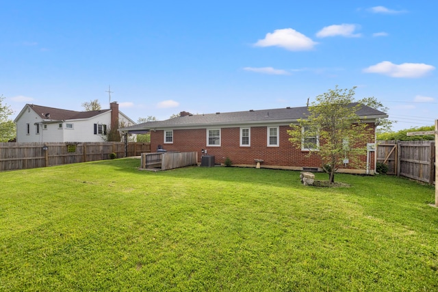 307 N Doctor St, Springfield, KY 40069 - rear view of property featuring a hot tub, central air condition unit, a lawn, brick siding, and a fenced backyard