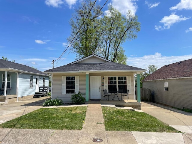 bungalow featuring a front yard, covered porch, and fence