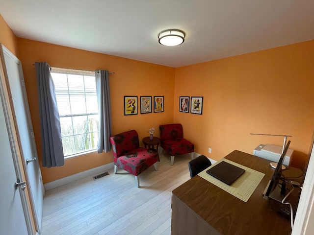 office with baseboards, visible vents, a healthy amount of sunlight, and light wood-style flooring