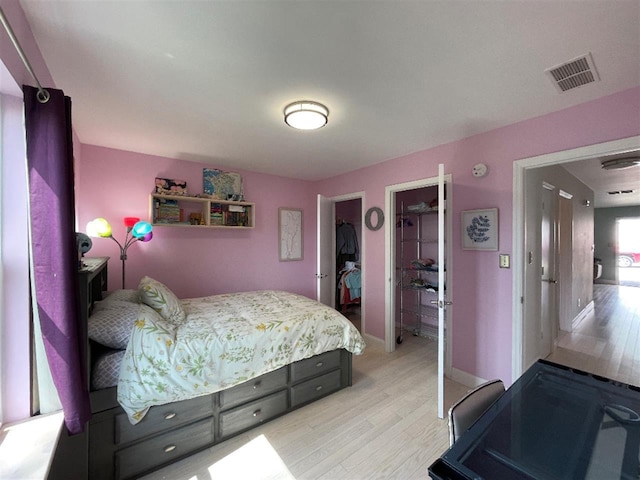 bedroom featuring baseboards, visible vents, and light wood-style flooring