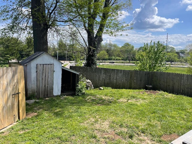 view of yard featuring an outbuilding, a storage shed, and a fenced backyard