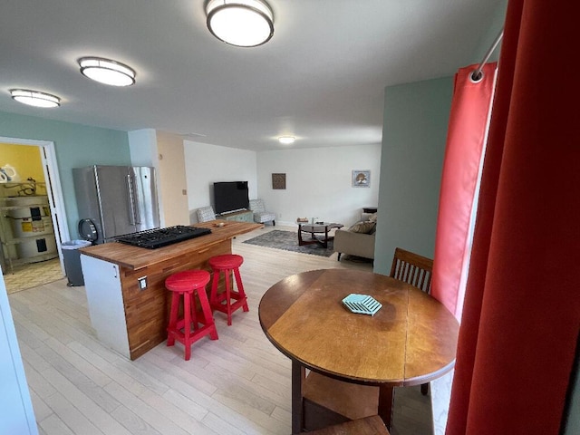 dining space featuring a fireplace and light wood-type flooring