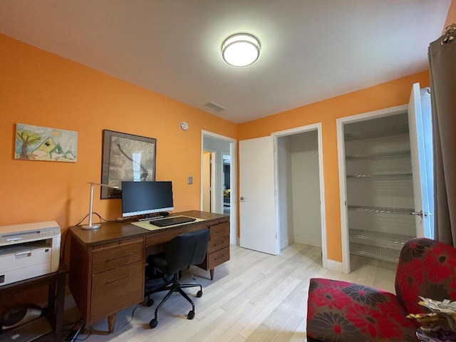 office space with baseboards, visible vents, and light wood-style flooring
