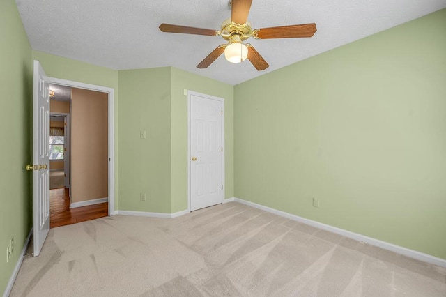 unfurnished bedroom featuring baseboards, ceiling fan, a textured ceiling, and carpet flooring