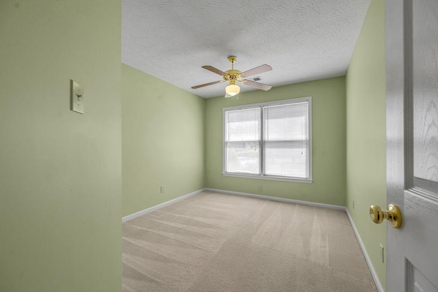 unfurnished room with a textured ceiling, ceiling fan, baseboards, and carpet floors